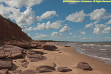 red beach, cliff, and clouds